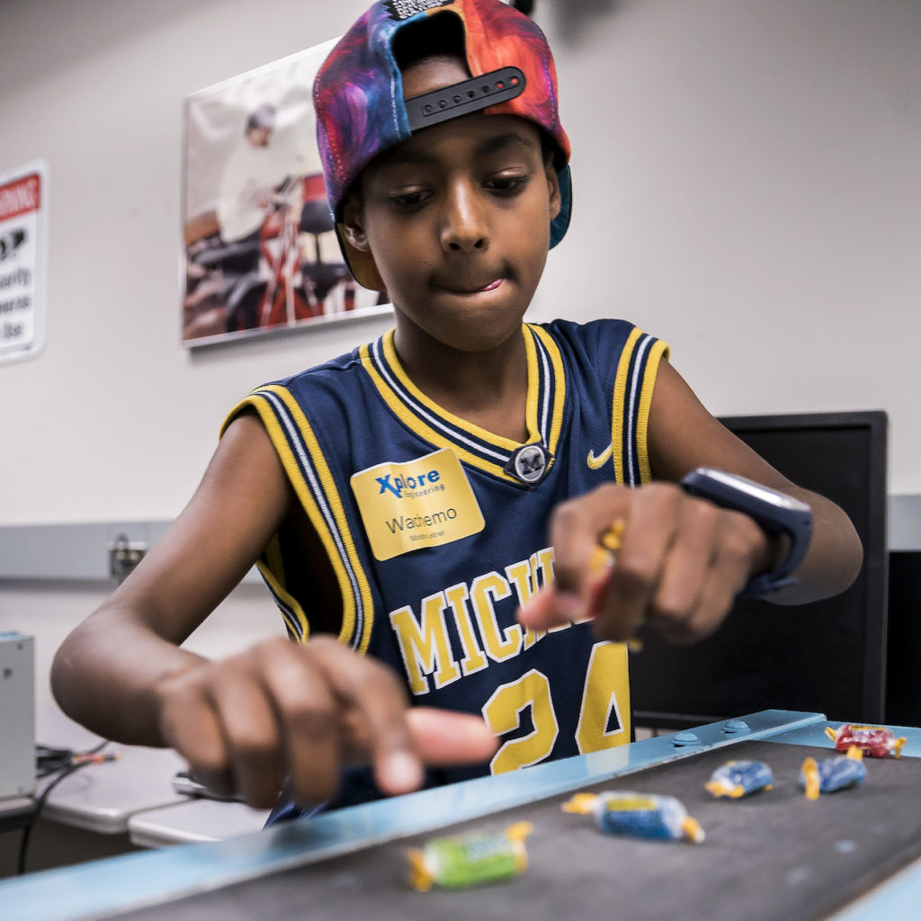 Kid works with jolly ranchers in the manufacturing process workshop